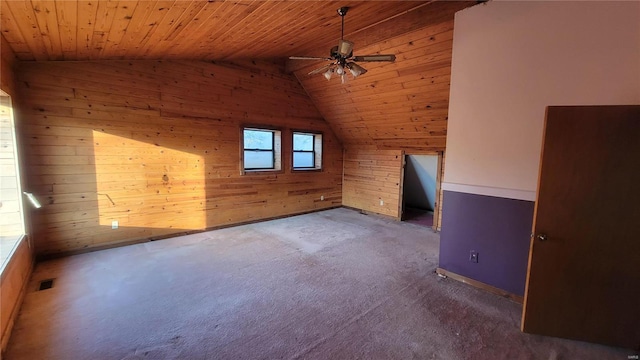 bonus room featuring wood walls, lofted ceiling, carpet flooring, wood ceiling, and a ceiling fan