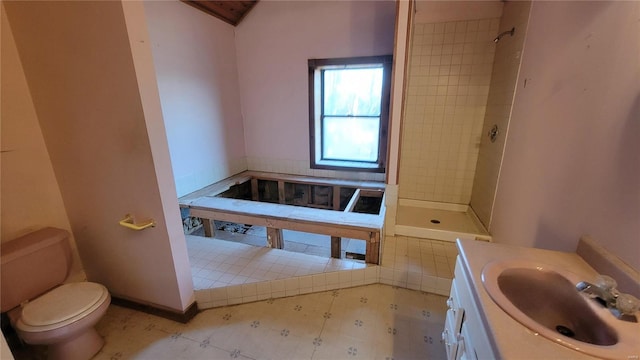 bathroom featuring toilet, vanity, and tiled shower
