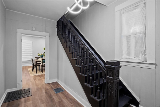 stairs with visible vents and wood finished floors