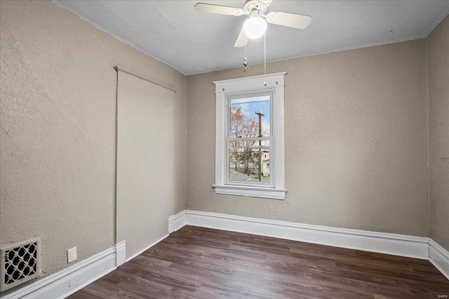 empty room with visible vents, baseboards, wood finished floors, and a ceiling fan