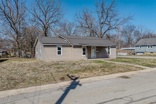 view of front of property with metal roof and a front lawn