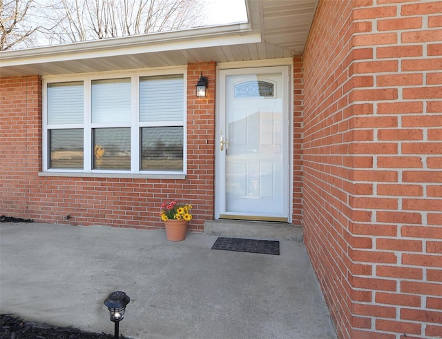 entrance to property featuring brick siding