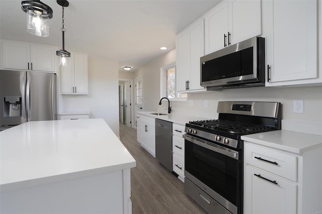 kitchen with stainless steel appliances, light countertops, dark wood-type flooring, and a sink