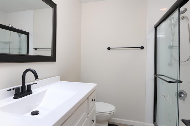 full bath featuring a stall shower, toilet, vanity, and baseboards