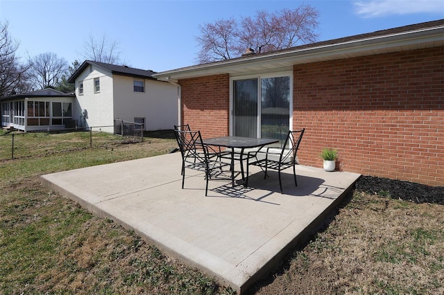 view of patio / terrace with a sunroom, outdoor dining space, and fence