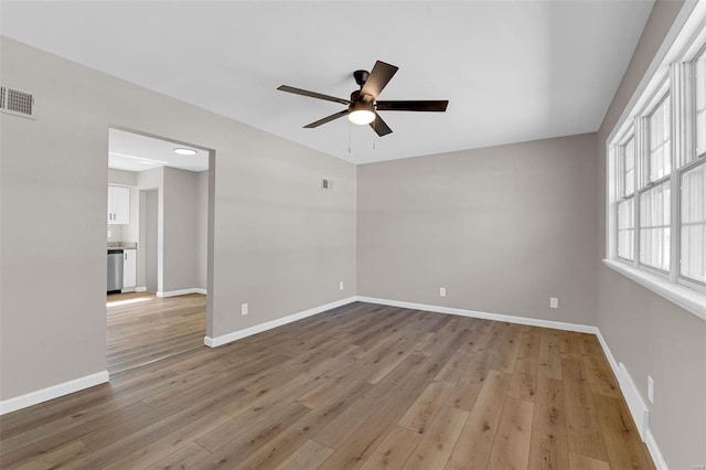 empty room featuring light wood-style floors, baseboards, and ceiling fan