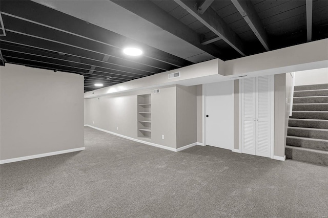 finished basement featuring stairway, baseboards, visible vents, and carpet flooring