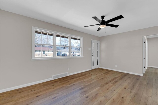 interior space with light wood-style flooring, baseboards, visible vents, and ceiling fan