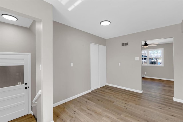 spare room featuring visible vents, baseboards, wood finished floors, and a ceiling fan