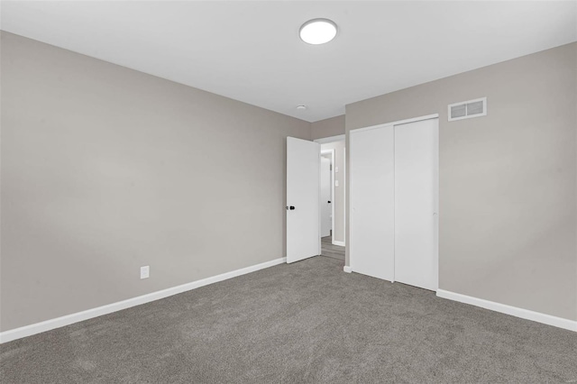 unfurnished bedroom with carpet flooring, baseboards, visible vents, and a closet