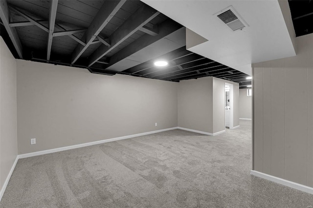 basement with visible vents, baseboards, and carpet