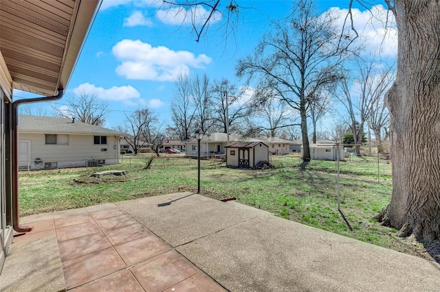 view of patio with a residential view, a storage shed, an outdoor structure, and fence