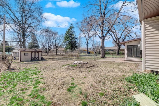 view of yard with a storage shed, an outdoor structure, and fence