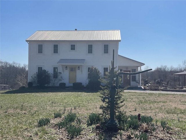 view of front of home with metal roof and a front yard