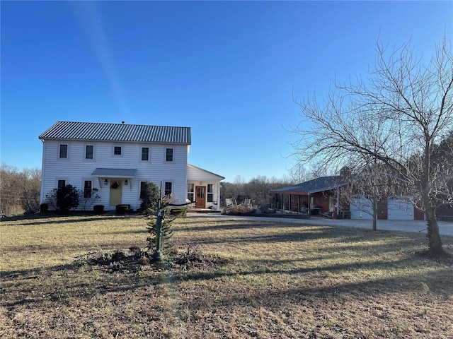 view of front of property with metal roof and a front lawn