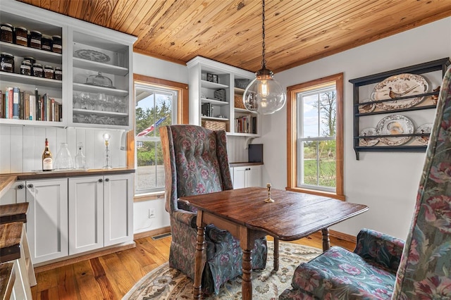 dining space with visible vents, light wood-style flooring, and wooden ceiling