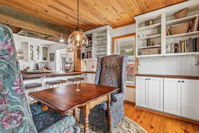 dining area featuring light wood-style flooring and wood ceiling