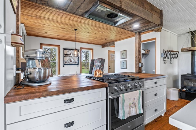 kitchen with wood ceiling, a wood stove, wooden counters, dark wood finished floors, and stainless steel range with gas cooktop