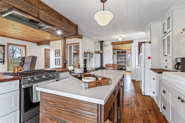 kitchen with gas stove, dark wood finished floors, wooden counters, wood ceiling, and freestanding refrigerator