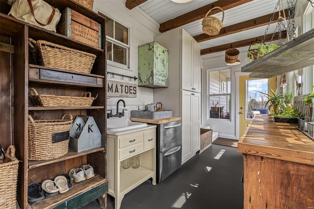 kitchen with white cabinets, beamed ceiling, baseboards, a sink, and open shelves