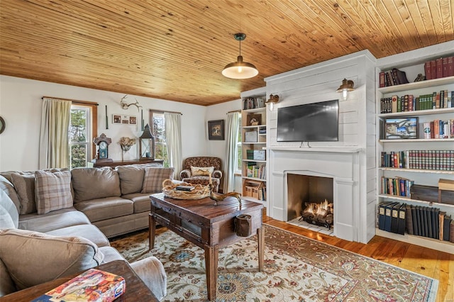 living area with a fireplace with flush hearth, wood finished floors, and wood ceiling
