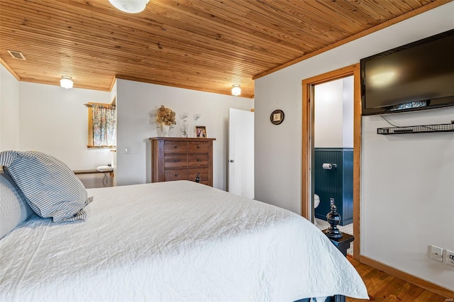 bedroom with visible vents, crown molding, baseboards, wood finished floors, and wood ceiling