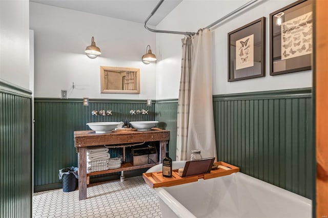 bathroom with a shower with curtain, a wainscoted wall, and vanity