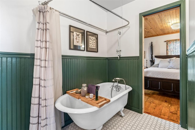 full bathroom featuring a freestanding bath, wood ceiling, ensuite bath, and wainscoting