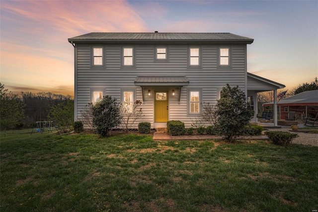 view of front of house featuring a front lawn and metal roof