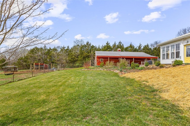 view of yard featuring an outbuilding, fence, and a pole building