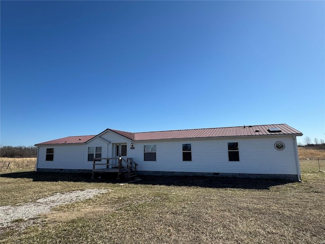 rear view of property with metal roof and crawl space