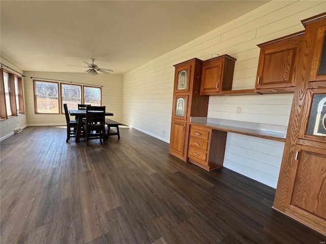 dining room featuring dark wood finished floors, baseboards, and ceiling fan