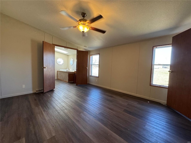 interior space with a textured ceiling, dark wood-type flooring, a ceiling fan, and vaulted ceiling