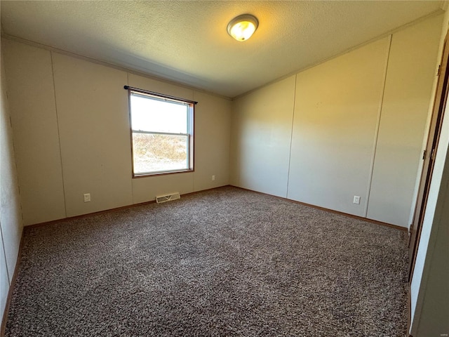 carpeted empty room featuring visible vents and a textured ceiling