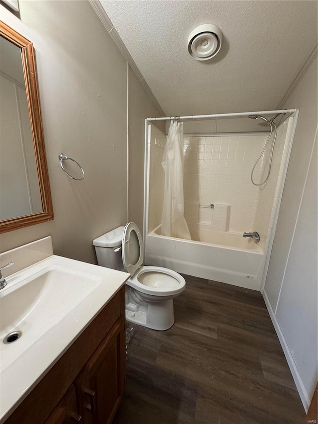 bathroom with toilet, shower / bath combo, a textured ceiling, wood finished floors, and vanity