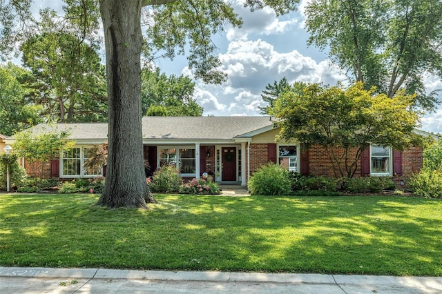 ranch-style home featuring brick siding and a front lawn