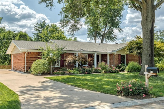 single story home with brick siding, concrete driveway, and a front lawn