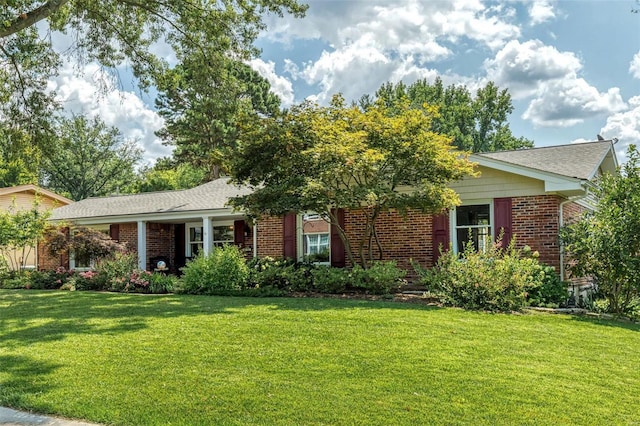 view of front facade with brick siding and a front lawn