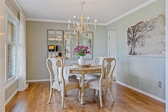 dining space with an inviting chandelier, wood finished floors, baseboards, and ornamental molding