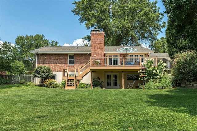 rear view of house with french doors, a lawn, a fenced backyard, and a wooden deck