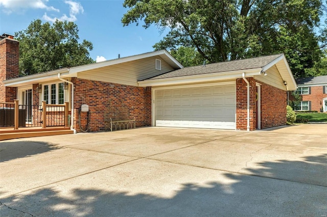 ranch-style home with concrete driveway, a garage, brick siding, and a chimney