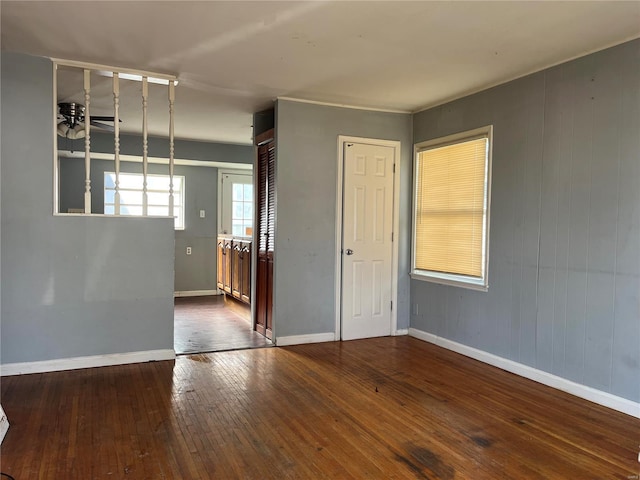 unfurnished room with hardwood / wood-style flooring and baseboards