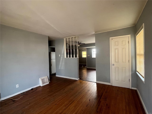 unfurnished room with visible vents, baseboards, ceiling fan, and hardwood / wood-style flooring