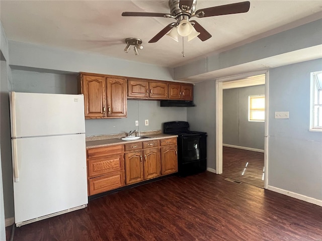 kitchen featuring black electric range, visible vents, brown cabinets, and freestanding refrigerator