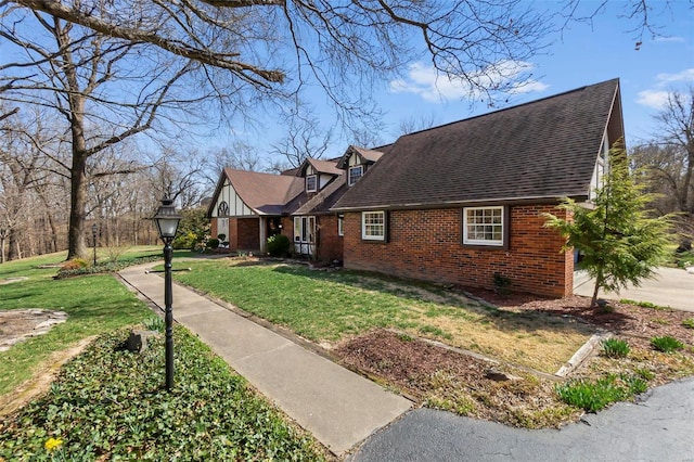 view of home's exterior with brick siding, roof with shingles, and a yard