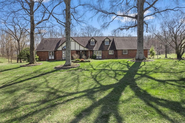 tudor-style house with brick siding and a front yard