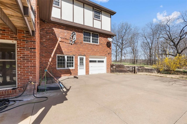 view of home's exterior featuring driveway, brick siding, and a garage