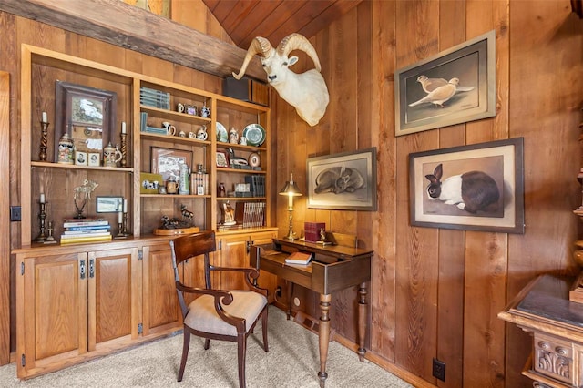 home office with vaulted ceiling, wood walls, and light colored carpet