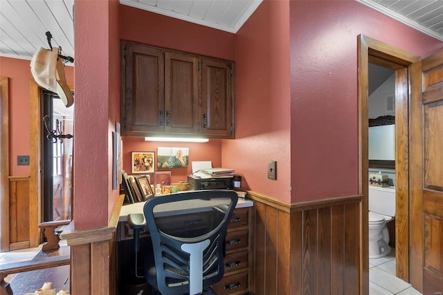 office space featuring a wainscoted wall, ornamental molding, wooden walls, and light tile patterned floors