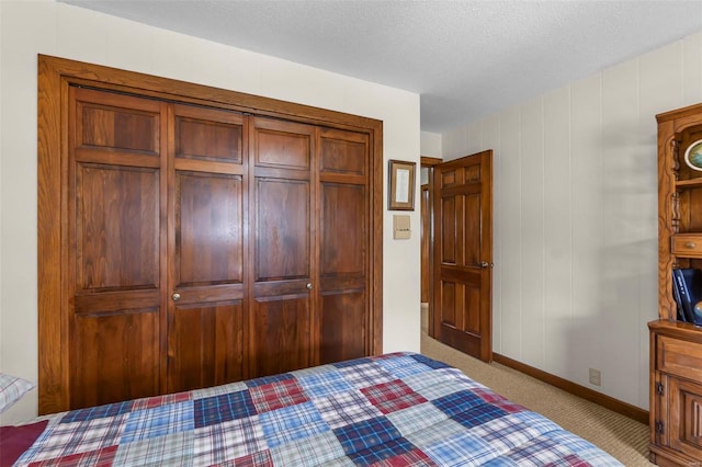 unfurnished bedroom with baseboards, a closet, carpet, and a textured ceiling